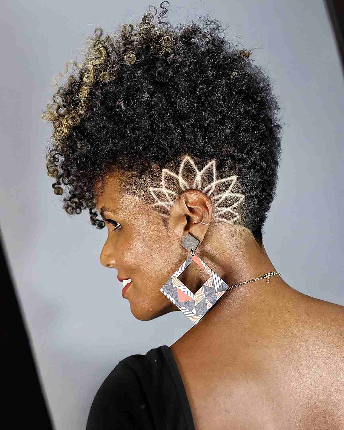 Natural afro hairstyle with shaved side patterns