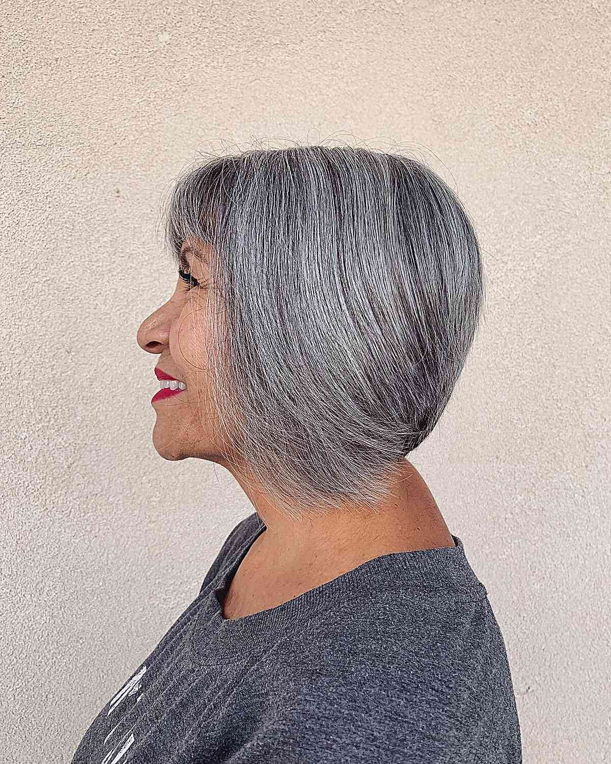 A graduated bob with straight-across bangs designed for gray hair