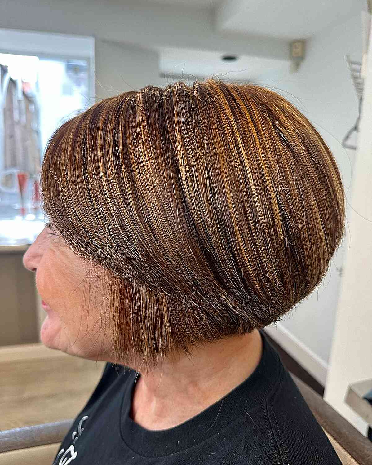 A super short bob with highlights and bangs swept to the side